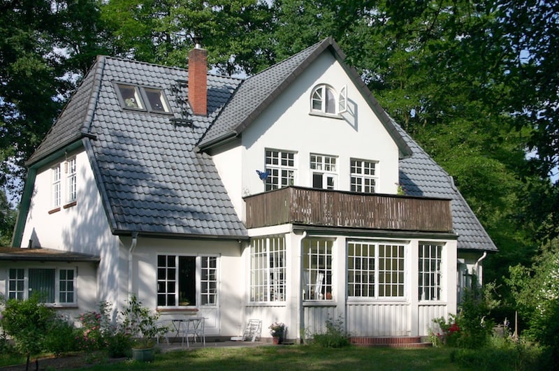 Weißes Haus mit Balkon und Garten.